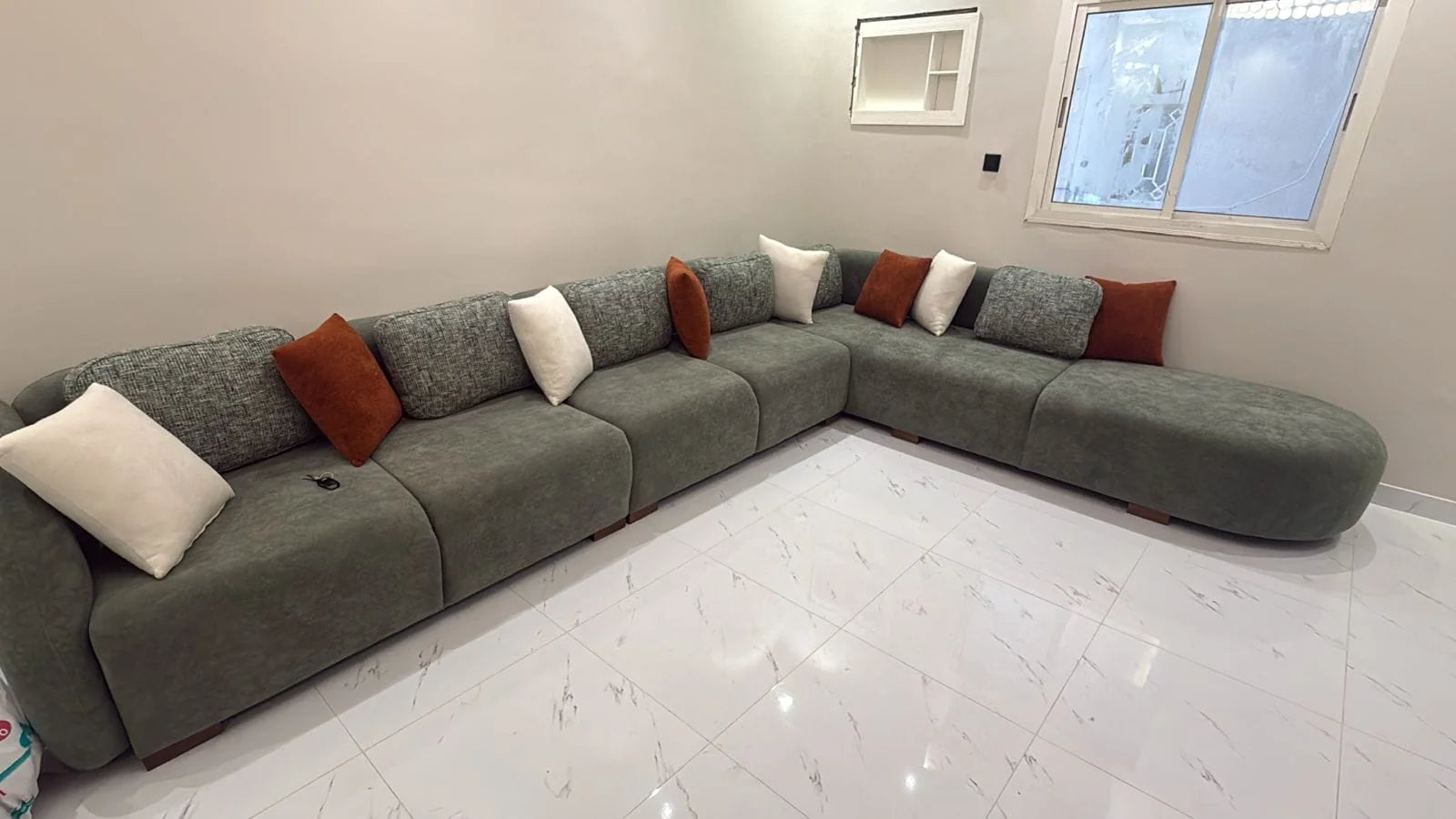 Green modular sectional with a rounded chaise end installed in a customer home