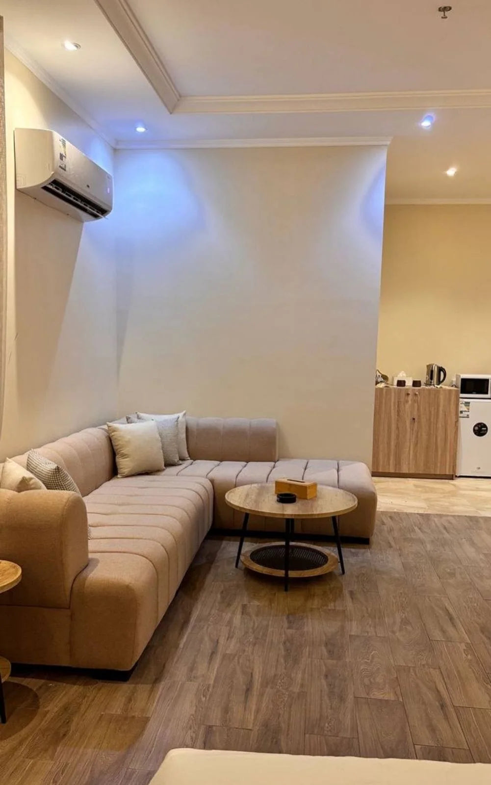 Compact beige channel sectional in an open customer living area