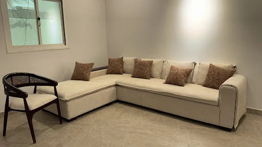 A cream corner sofa with warm cushions — KLIK customer-home photograph