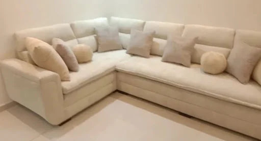 A soft cream corner with layered cushions — KLIK customer-home photograph