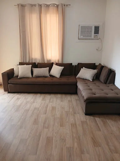 A brown corner sofa with light cushions — KLIK customer-home photograph