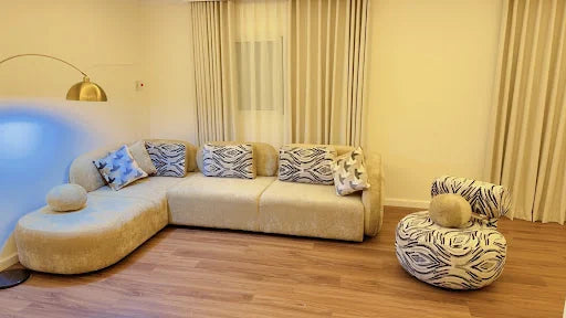 A curved corner sofa with a matching pouf — KLIK customer-home photograph