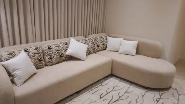 Cream chaise sectional with patterned cushions in a finished customer room