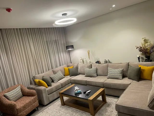 Full-room view of a beige sectional and accent chair