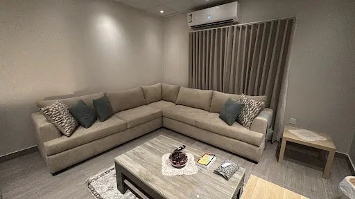 Beige corner sofa with blue and patterned cushions in Mohammed Hindi’s home